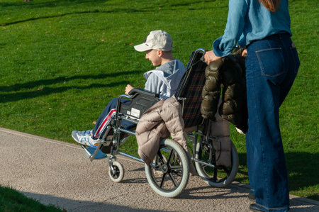 Krasnodar, Russia - April 14 2021: Boy in a wheelchair looks out into the distance in sunny weather.のeditorial素材