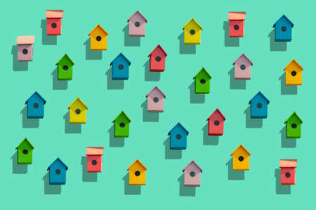 3D Illustration of colourful bird houses in red green orange pink yellow and blue on a light green background.の写真素材