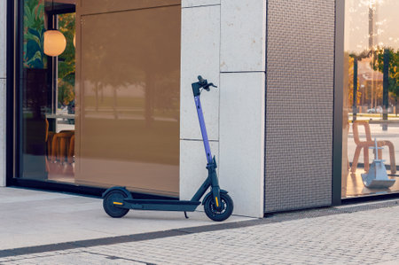 Electric urban transportation. Human is ready to discover the urban city in autumn at sunset with electric scooterの写真素材