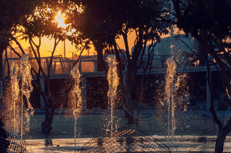 Sunset city fountain with frozen water dropsの写真素材