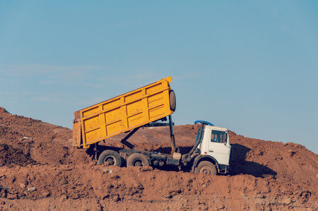 Dump truck is dumping gravel on an excavation siteの写真素材