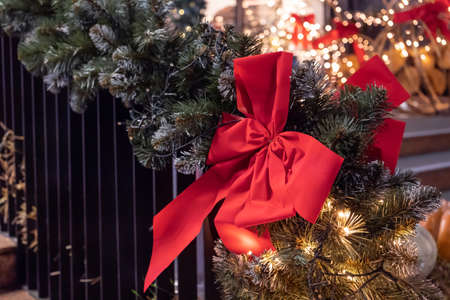 Christmas holiday background. Silk red bow with ribbon, balls, fir-tree branches, berries. New Year backgroundの写真素材