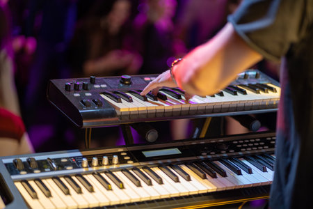 Close up of a keyboardist musician at work at a concert. Musician playing keyboard at the party.の写真素材