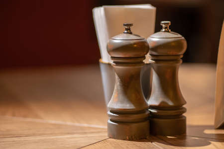Close-Up Of Pepper Salt Seasoning Wooden Glinders On Table. Salt and pepper shakers on wooden table.の写真素材