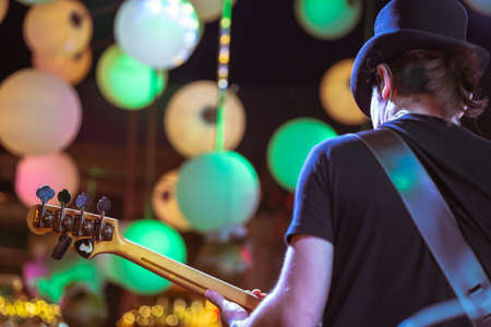 Electric Bass guitar player on stage. Rear view of musician.の写真素材