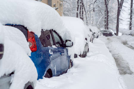Snowfall in the city. Car covered in several inches of snow. Car almost totally buriedの写真素材