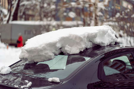 Snowfall in the city. Car covered in several inches of snow. Car almost totally buried.の写真素材