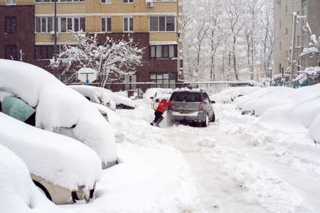 Krasnodar, Russia - January 23 2022: Man Pushing Car On Snow Covered Road.の写真素材