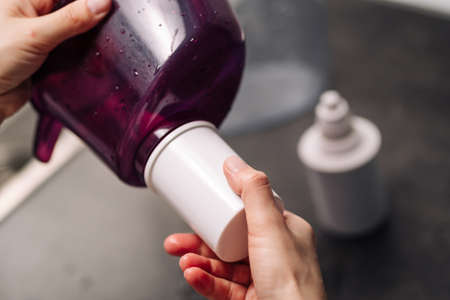 Woman replacing filter in a water pitcher. Female hand removes an old tap water purification...