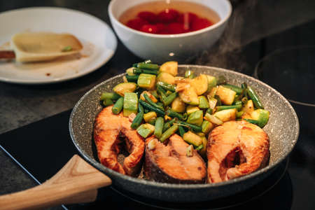 Grilled trout steak. Stir frying. The zucchini and green beans are pan fried. Electric hob.の写真素材