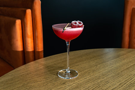 Summer cocktail garnished with raspberry berries. Pink cold beverage on bar terrace.の写真素材