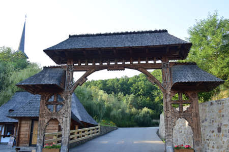 The Maramures gate, built of oak wood, generally on at least three carved pillars with different traditional floral motifs and the upper threshold of the gate covered with shinglesの写真素材