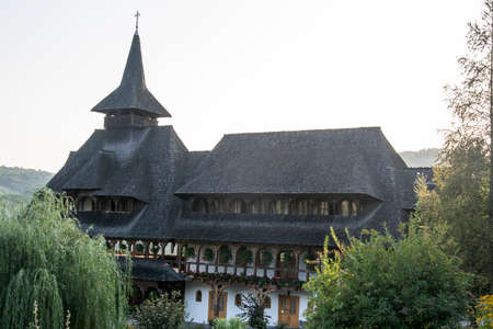 Barsana Orthodox Abbess, a multi-storey building in the Maramures style of wooden churches, with multiple roofs, beautifully decorated, in traditional style, intended for monastic ruleの写真素材