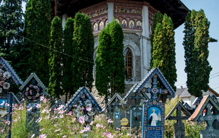 The Romanian Orthodox Church with a slender tower, specific to the churches of MaramureÅ and the Cover of the frame made of glazed tile in the chromatic of the crosses from the merry cemetery.のeditorial素材