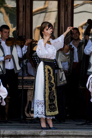 Folk artists performing folk music at Novaci Romania in national pastoral costumes made of linen cloth sewn with traditional black motifs men wear traditional round black cloth hatsのeditorial素材