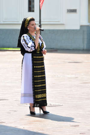 Folk artists performing folk music at Novaci Romania in national pastoral costumes made of linen cloth sewn with traditional black motifs men wear traditional round black cloth hatsのeditorial素材