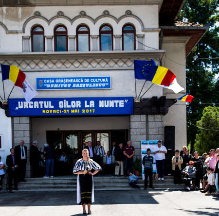 Folk artists performing folk music at Novaci Romania in national pastoral costumes made of linen cloth sewn with traditional black motifs men wear traditional round black cloth hatsのeditorial素材