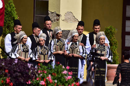 girls and boys from the Sibiu meadow dressed in pastoral costumes men wear round black cloth hats, a...