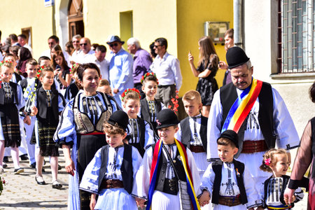The mayor of Poiana Sibiului  Romania, dressed in a national shepherd's linen suit, sewn with traditional black motifs, wears a round black cloth hat, a wide leather kimir and a tricolor scarfのeditorial素材