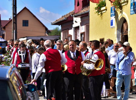 Hermannstadt marching band consisting of wind and percussion musicians dressed in uniforms consisting of black pants, red jacket, and white shirtsのeditorial素材