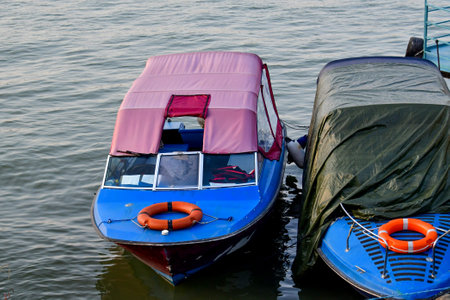 Boat on the water with blue and pink lifebuoy.の写真素材