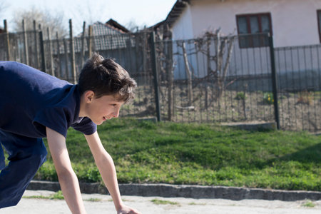 A young boy is involved in sports on the street in the spring.の写真素材