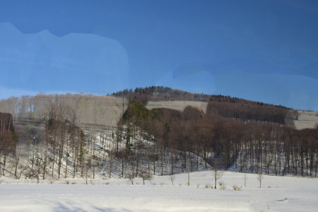Winter landscape in the mountains. Snowy meadow and blue sky.の写真素材