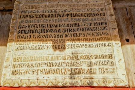 Close-up of an ancient religious sign on a wooden wall.