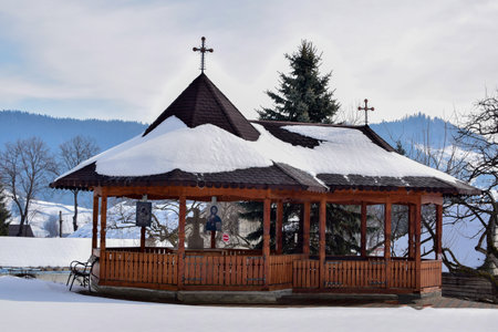 Wooden gazebo on a snowy field in the mountainsの写真素材