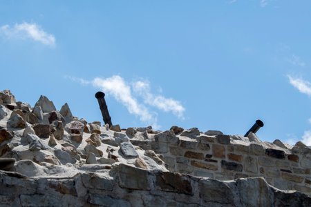 Old stone wall with blue sky and white clouds on the background.の写真素材