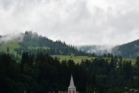 Mountain landscape with clouds and church in the foreground, Austria.の写真素材