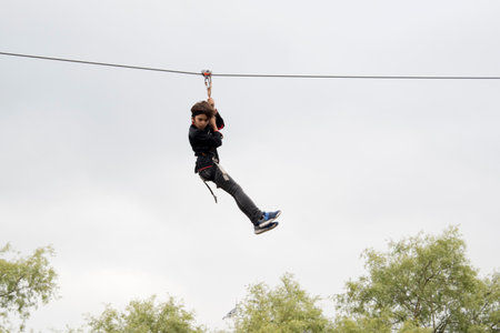 Little boy having fun on a tightrope in the park.
