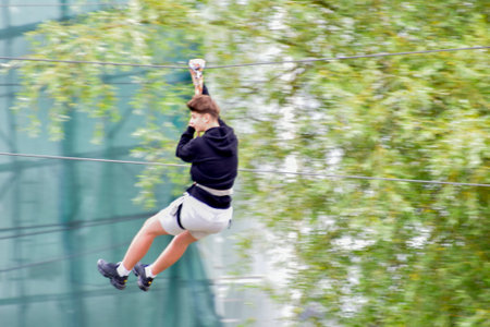 A high angle shot of a young woman hanging on a rope in a parkの写真素材