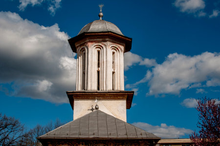 Tower of the church against the blue sky with white clouds.の写真素材