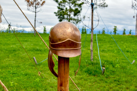 Old military helmet on a wooden stand on the background of the fieldの写真素材