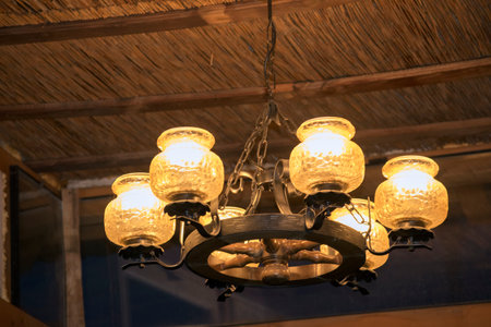 Vintage chandelier hanging on a wooden wall in a cafe