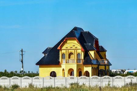 Beautiful yellow house on the background of blue sky, Romaniaの写真素材