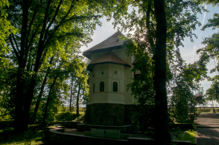 Church in the park in the summer. The church is surrounded by green trees.