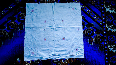 A piece of cloth on a dark blue background. Toned.