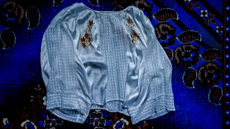 White blouse with embroidery on a blue background. Toning.