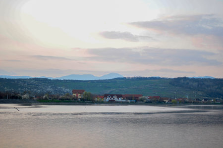 Beautiful sunset over the lake and the village of Krynica