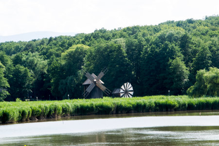 Old wooden windmill on the bank of the river in the villageの写真素材
