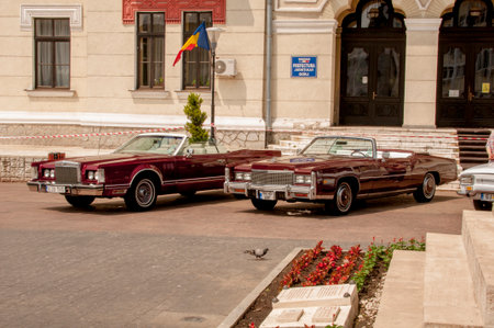 Old American cars parked near a building.
