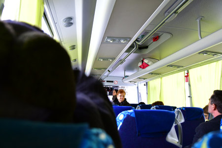 Interior of a passenger bus with people in the back seat.の写真素材