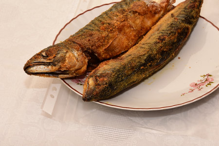Fried mackerel fish on a plate on a white tableclothの写真素材