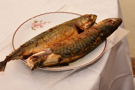 fried mackerel fish on a plate on a white tableclothの写真素材
