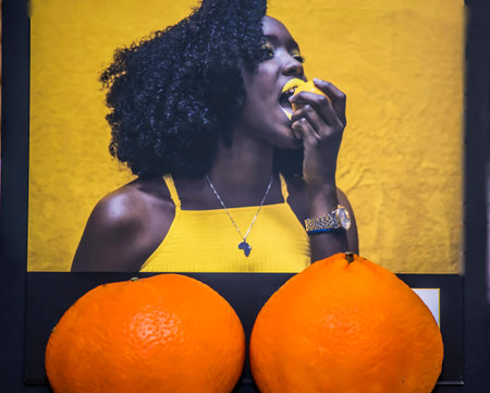 Beautiful african american woman with oranges in the studio.