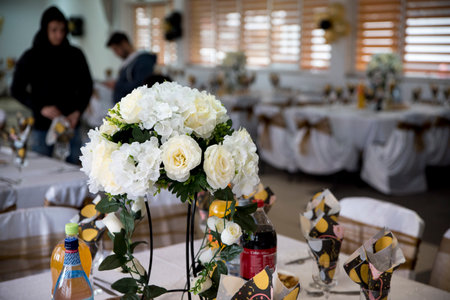 Wedding table decoration with white roses and candles in the restaurant