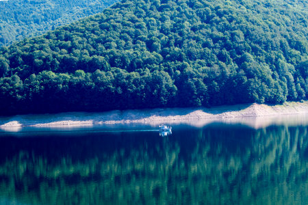 Aerial view of a small motor boat on the lake in the mountains