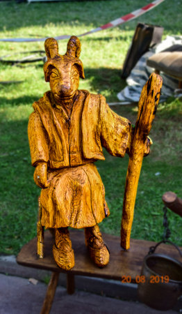 Wooden statue of a man with a wooden stick in his handの写真素材